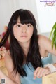 A woman with long black hair sitting at a table.