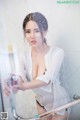 A woman in a white shirt is taking a shower.