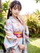 A woman in a blue and pink kimono posing for a picture.