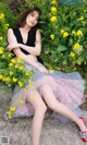 A woman sitting in a field of yellow flowers.