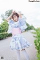 A woman in a blue and pink kimono is posing for a picture.