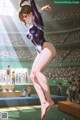 A woman in a purple leotard doing gymnastics in front of a crowd.