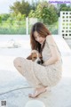 A woman kneeling down with a dog on a leash.