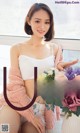 a woman sitting on a window sill holding a bouquet of flowers