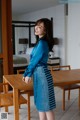 A woman standing in front of a wooden table.