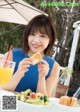 A woman sitting at a table eating a sandwich.