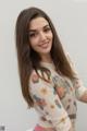 A young woman with long brown hair posing for a picture.